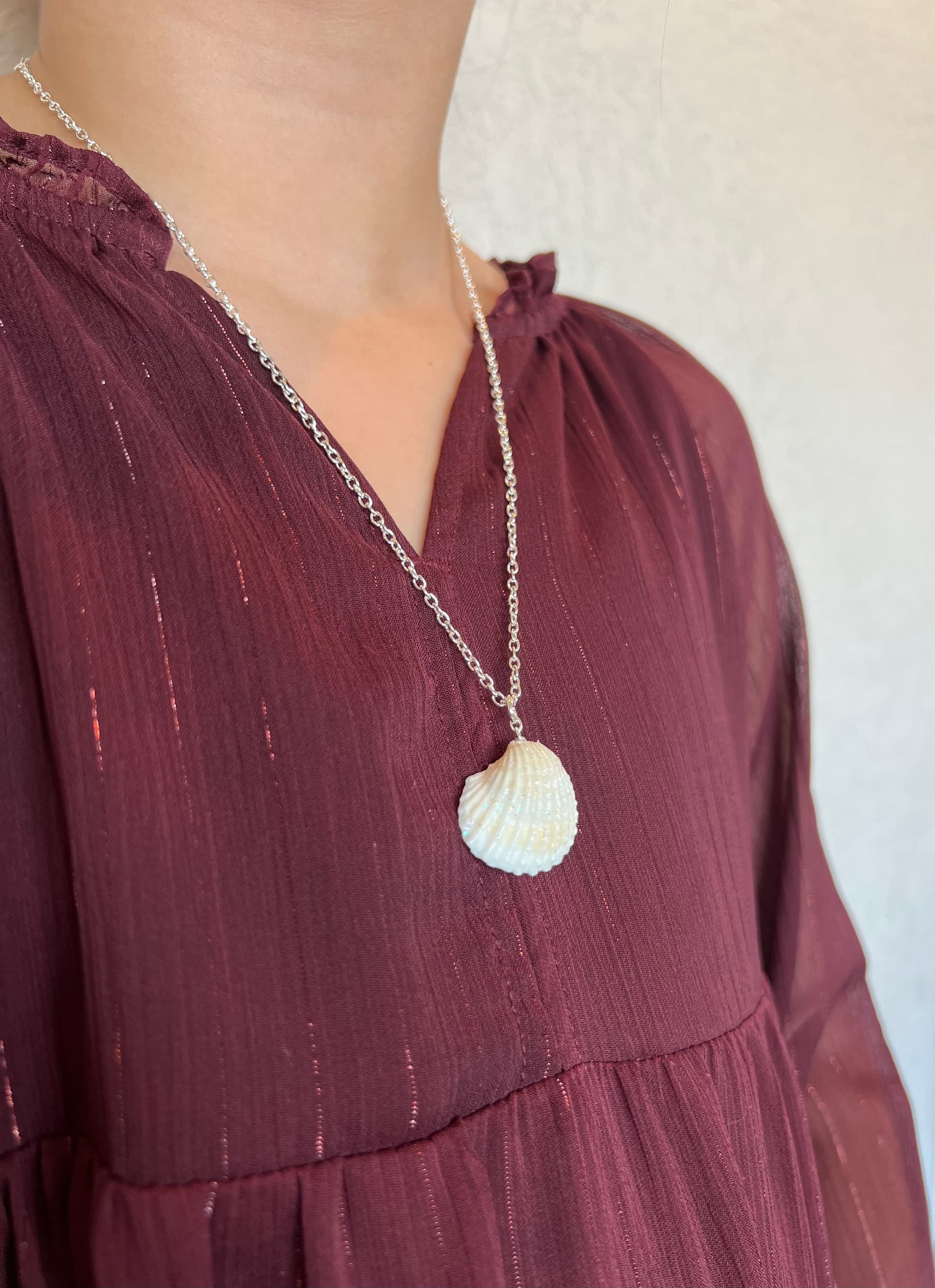 Seashell necklace worn on burgundy dress